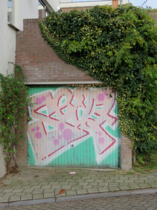 828707 Gezicht op de garagebox naast het pand Draaiweg 58 te Utrecht, met graffiti op de garagedeur.